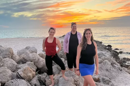 Three women at beach sunset estero