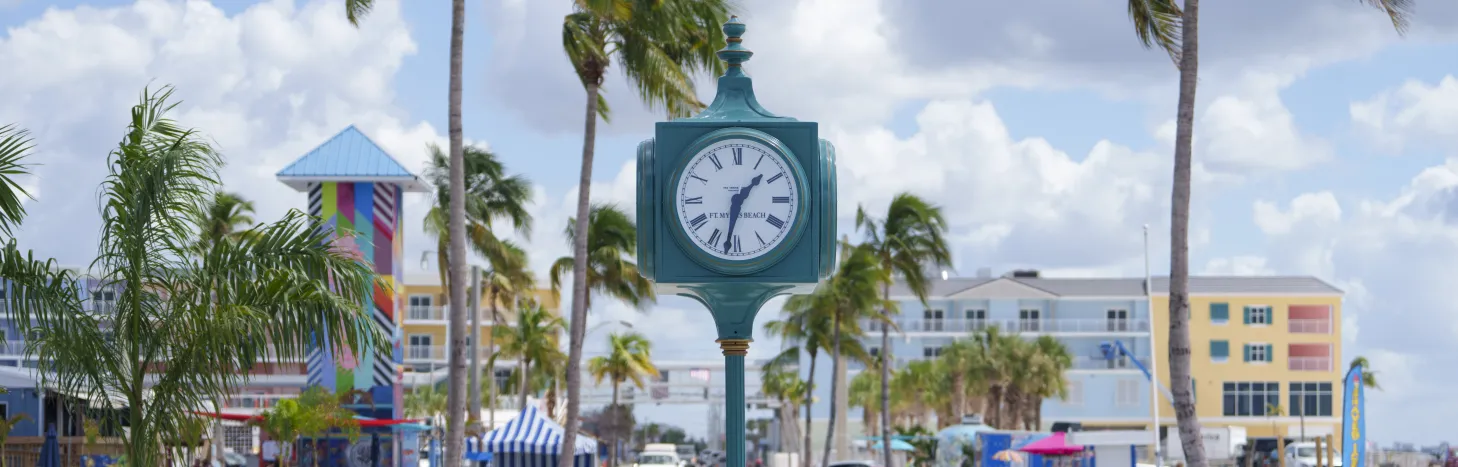 A clock on a pole in the middle of a sidewalk