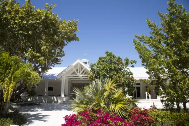 Photo of the Captiva Civic Center with green trees and pink bougainvillea flowers surrounding the building.
